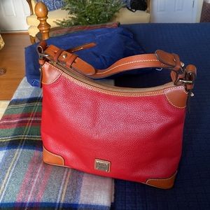 Dooney & Bourke Holiday red pebble leather bag with light brown trim.